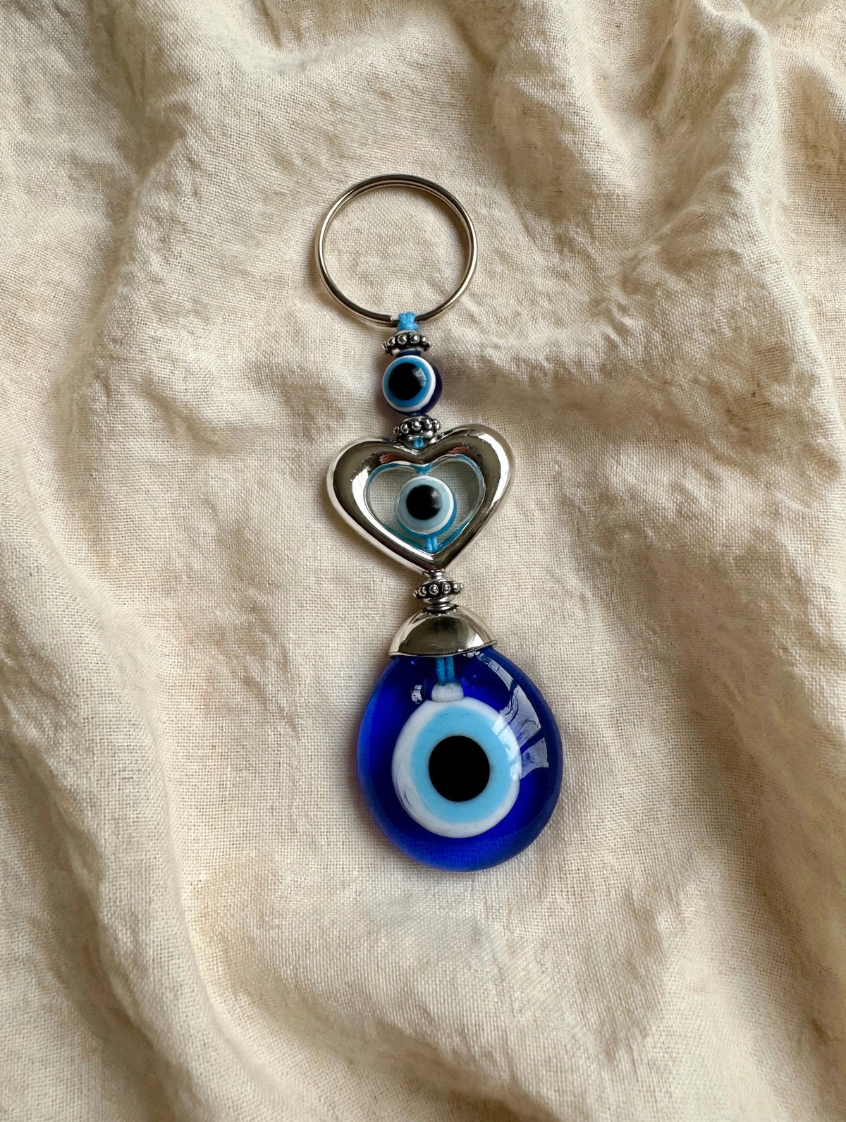 63fe71384f2da238419a4f9e_evil-eye-keychain-linen-hq_1789038770535.jpeg